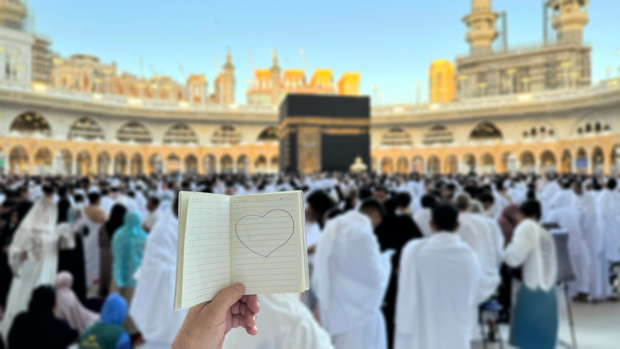 Ein Pilger hält ein kleines Notizbuch mit einer Herz-Zeichnung vor der Kaaba in Mekka, Saudi-Arabien. (Symbolbild)