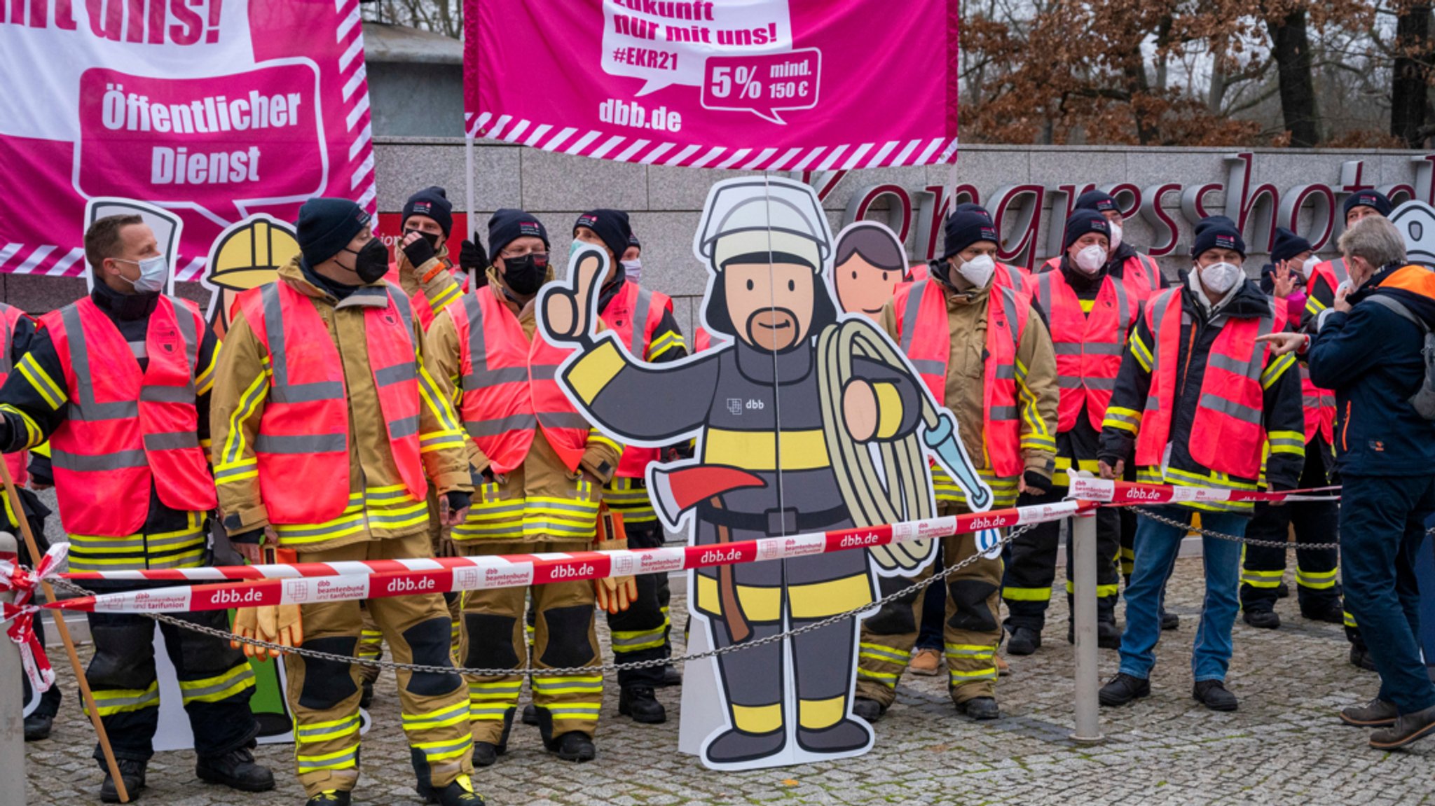 Vor dem Verhandlungsort für die dritte Verhandlungsrunde im Tarifkonflikt vom Öffentlichen Dienst stehen Feuerwehrleute.