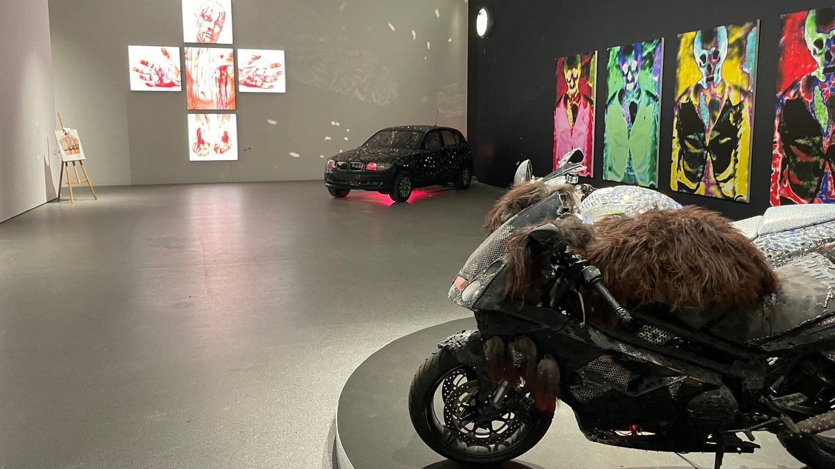 Kruzifix und Motorrad in der Ausstellung