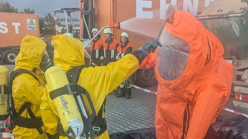 Ein Mann besprüht einen Anzug. | Bild: FFW Gunzenhausen/Stefan Brändlein Ein Mann besprüht einen Anzug.