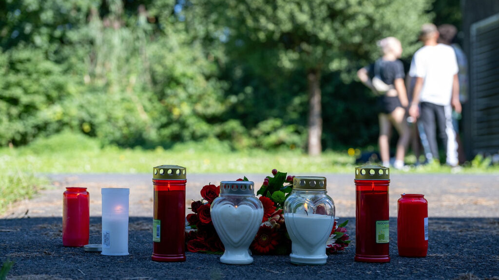 09.09.2023, Bayern, Lohr Am Main: Kerzen und Blumen sind vor einem Seiteneingang des Schulzentrums in Lohr am Main abgelegt. Am Morgen nach dem Fund eines toten Jugendlichen auf dem Schulgelände kommen immer wieder Menschen vorbei, die das Opfer gekannt haben und halten inne. Foto: Pia Bayer/dpa +++ dpa-Bildfunk +++