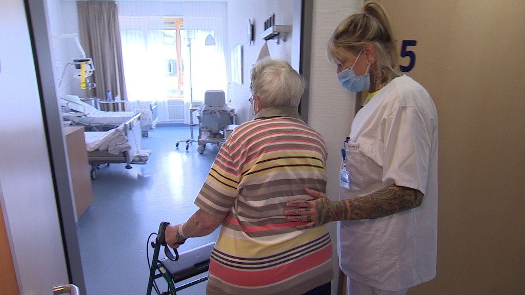 Am Uniklinikum Würzburg hilft eine Pflegerin einer Patientin ins Zimmer