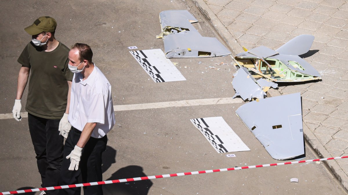 Vor einem beschädigten Wohnblock legten Ermittler Reste einer Drohne ab