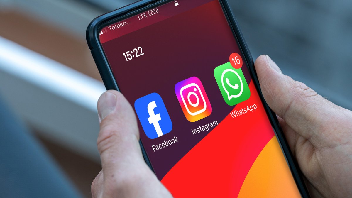 (Symbolbild) User hält Smartphone in den Händen, das drei Meta-Apps anzeigt