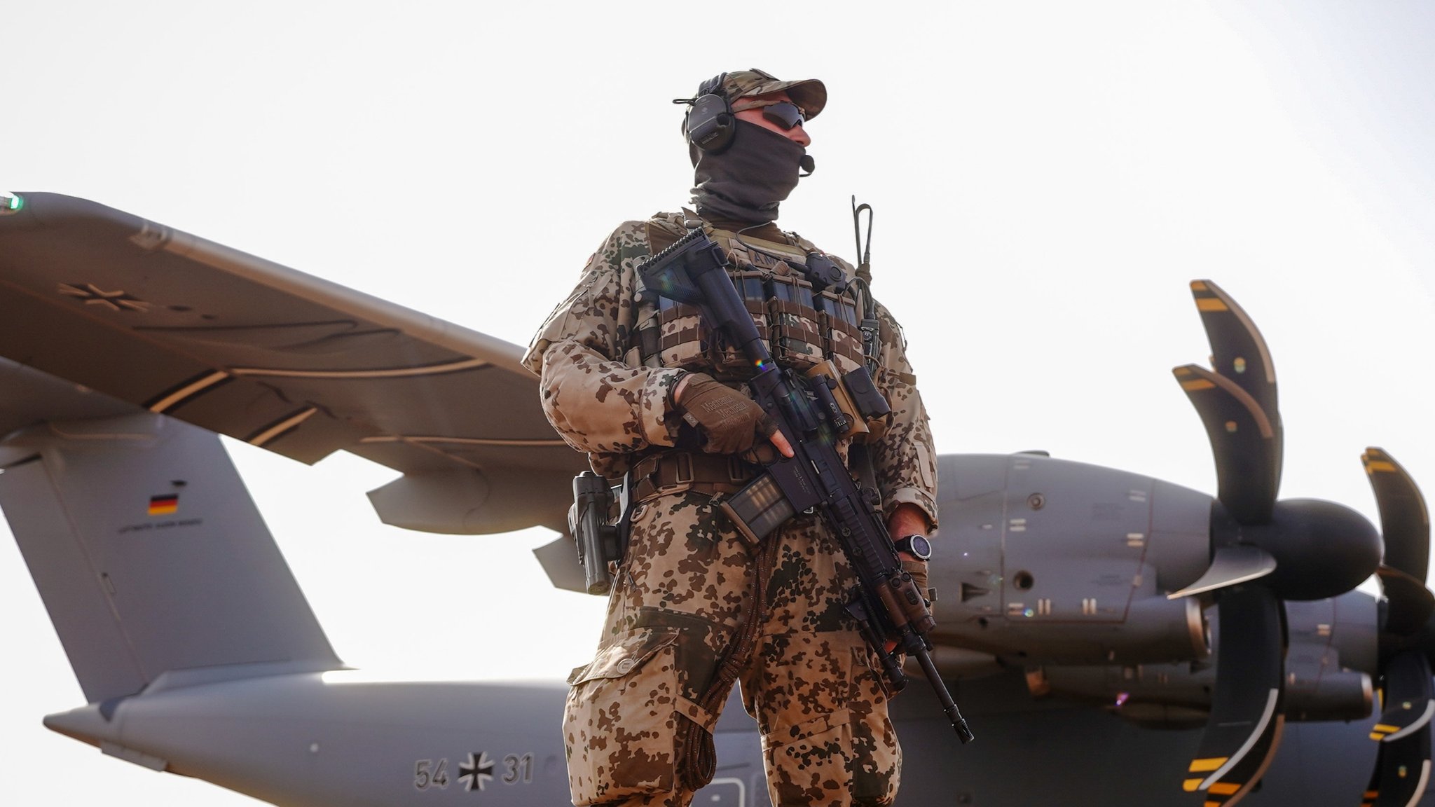 Bundeswehr - Episodencover Soldat in Kampfuniform mit Waffe vor Kampflugzeug mit deutschen Hoheitszeichen,
