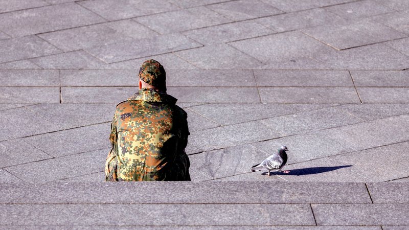 Ein Bundeswehr-Soldat sitzt auf dem Boden, daneben eine Taube (Archiv- und Symbolbild) | Bild: picture alliance / Geisler-Fotopress|Christoph Hardt Ein Bundeswehr-Soldat sitzt auf dem Boden, daneben eine Taube (Archiv- und Symbolbild)