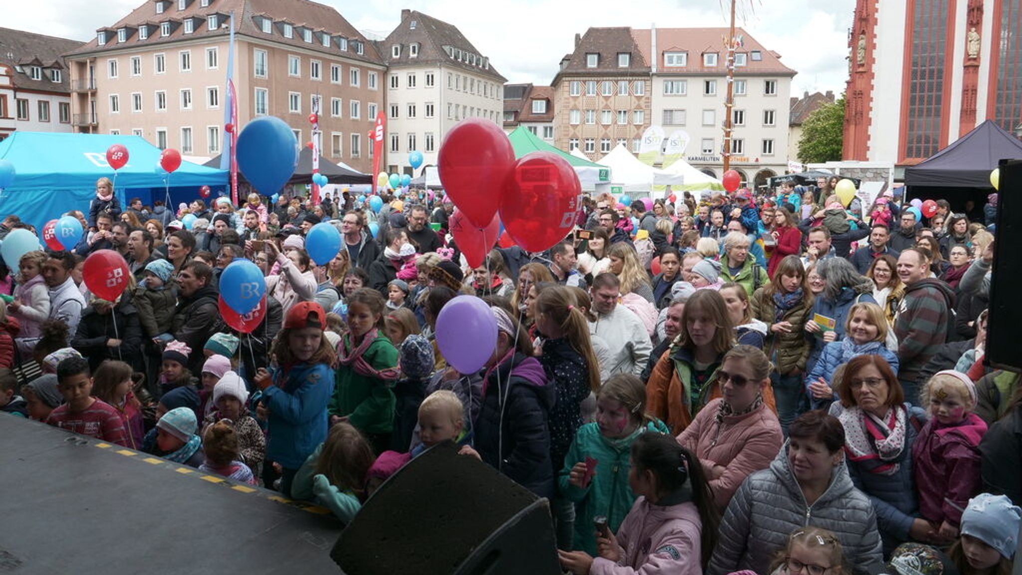 05.05.2019, Würzburg - Zum 44. Internationalen Kinderfest kommen rund 35.000 Besucher in die Würzburger Innenstadt. Besondere Attraktion ist heuer der Besuch der Fernsehlieblinge Biene Maja und Willi (hier im Bild BR-Reporterin Irina Hanft und Willi). Das Internationale Kinderfest wird alljährlich von der Stadt Würzburg, der Deutschen Lepra- und Tuberkulosehilfe (DAHW) und dem BR-Studio Mainfranken veranstaltet. Auf zwei Bühnen am Obelisken und am Falkenhaus präsentiert der BR unter dem Motto "Kinder spielen für Kinder" ein großes Unterhaltungsprogramm. Im Bild: Publikum vor der BR-Bühne.