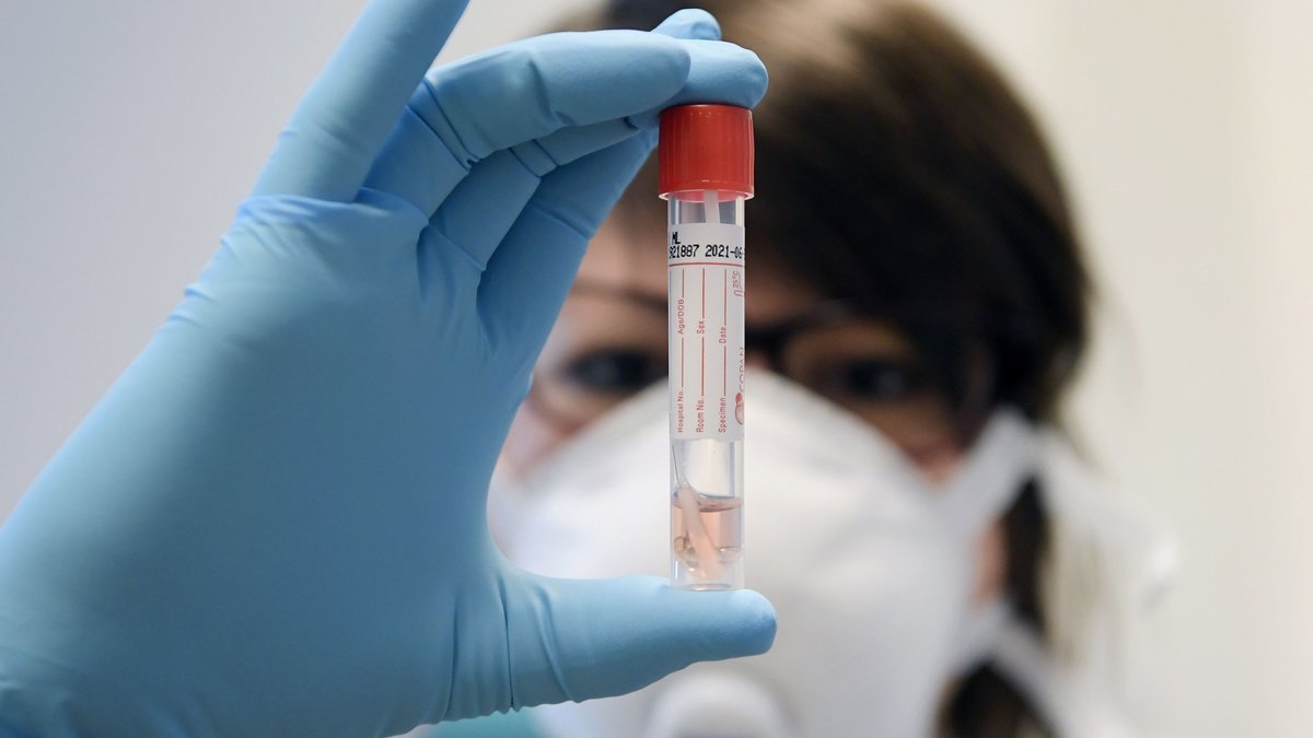 Eine Labor-Mitarbeiterin schaut auf einen Corona-Test (Symbolbild)