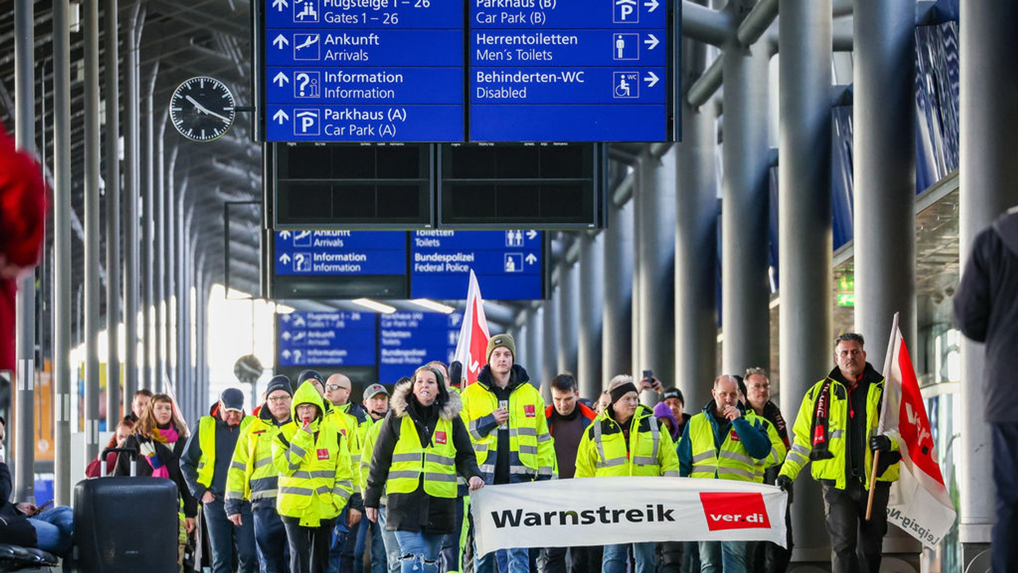 ARCHIV - 01.02.2024, Sachsen, Schkeuditz: Beschäftigte der Mitteldeutschen Flughafen AG gehen während eines Warnstreiks durch den Flughafen Leipzig/Halle. Eine Woche später gibt es bei Verhandlungen keine Einigung. (zu dpa: «Verdi lehnt Angebot für Luftsicherheitskräfte ab») Foto: Jan Woitas/dpa +++ dpa-Bildfunk +++