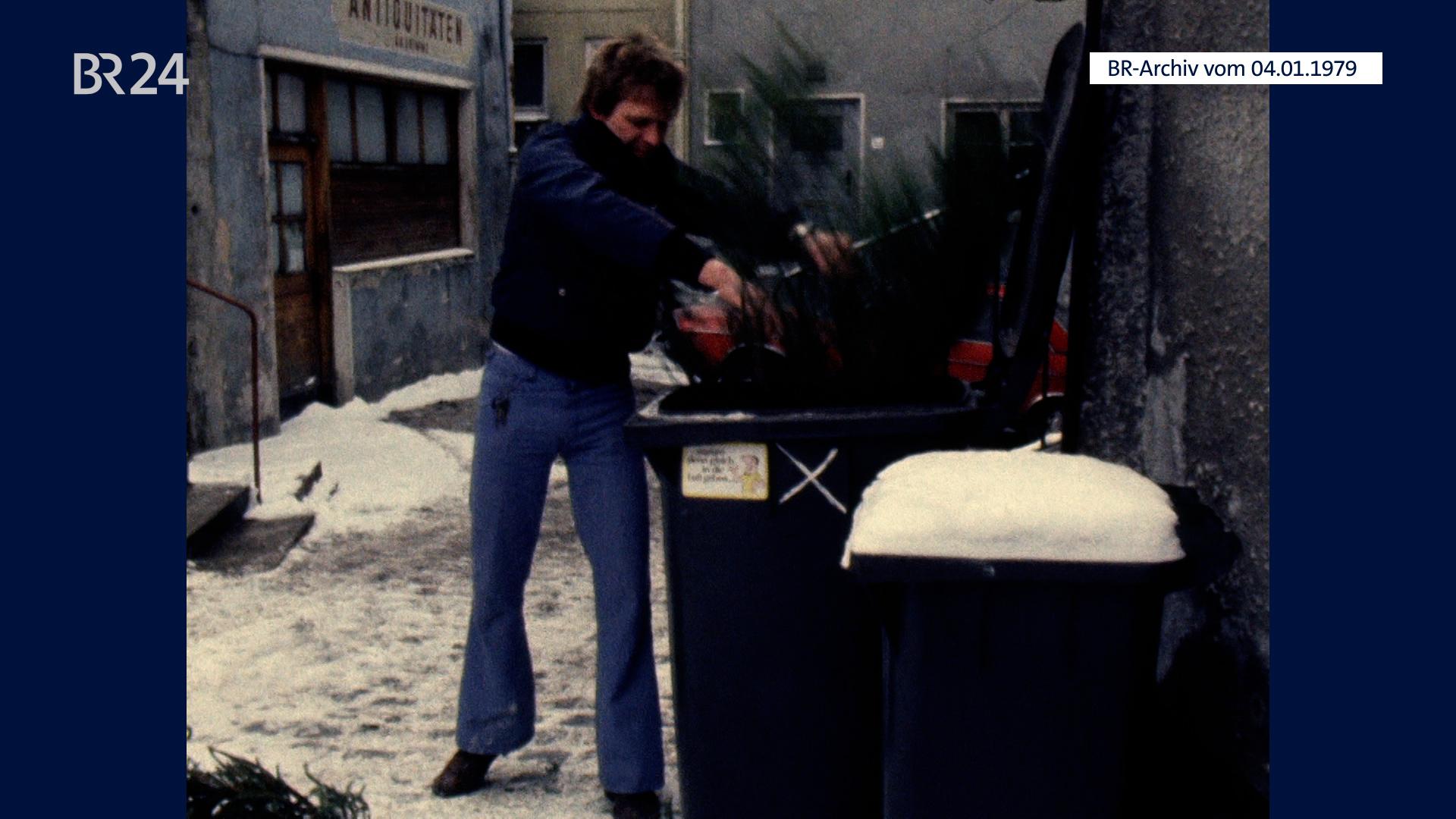 Christbaum wird in der Mülltonne entsorgt