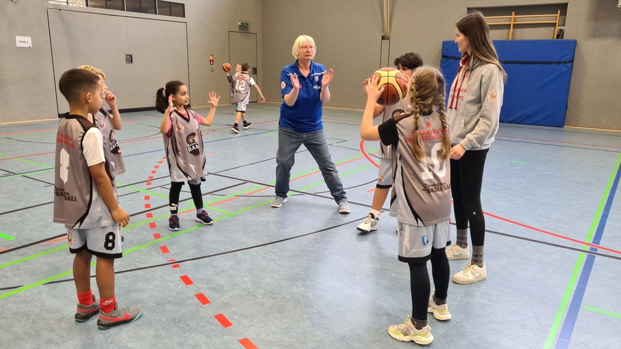 Kinder beim Wurftraining mit zwei Leiterinnen.