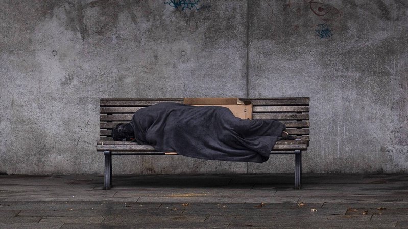 Das Beitragsbild des Dok5 \"Angst haben fast alle - Gewalt im Leben von Obdachlosen\" zeigt einen schlafenden Obdachlosen auf einer Bank in Berlin.