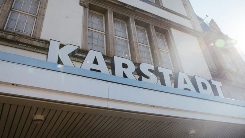 In Großbuchstaben ist an der Fassade eines Gebäudes "Karstadt" zu lesen. 