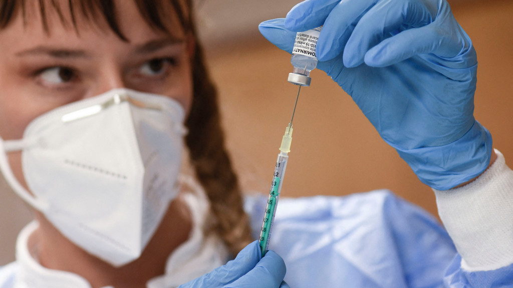 Eine medizinische Fachangestellte zieht in Schützausrüstung eine Spritze mit Impfstoff gegen das Coronavirus auf. 