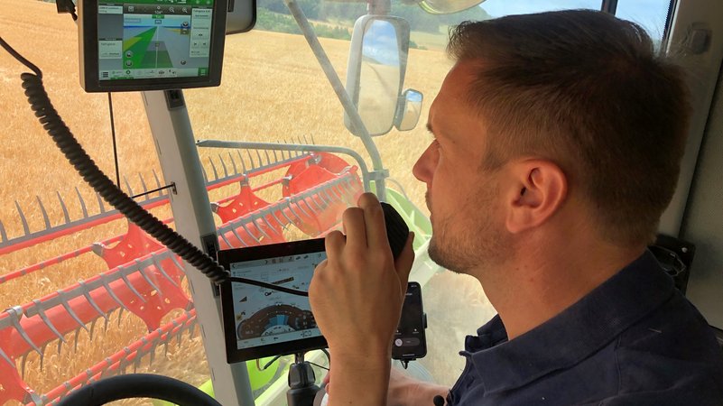 Alles im Blick: Landwirt Andreas Dörr auf dem Fahrersitz seines Mähdreschers mit Monitoren