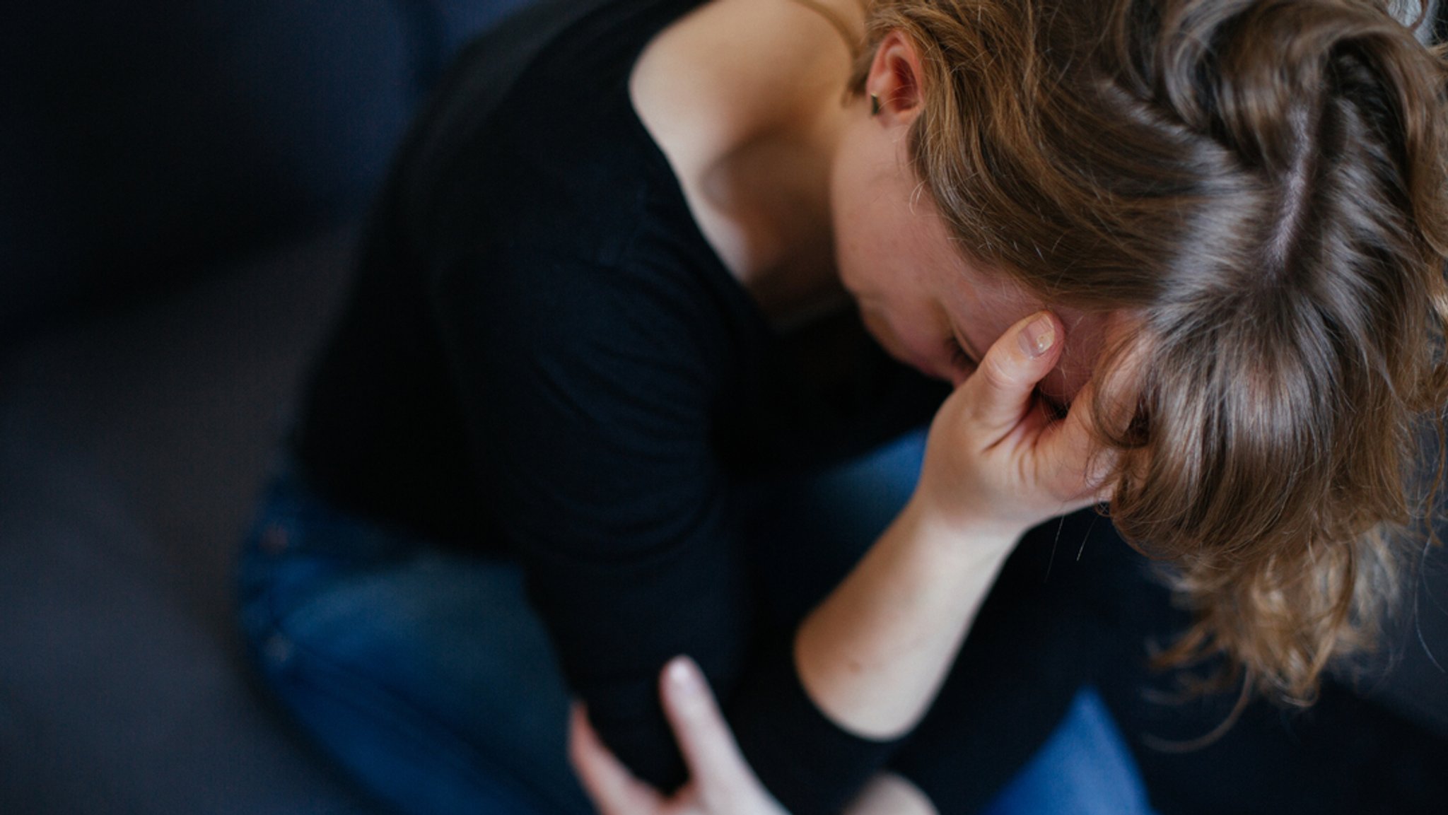 Symbolbild: Weinende Frau, die das Gesicht in der Hand vergräbt