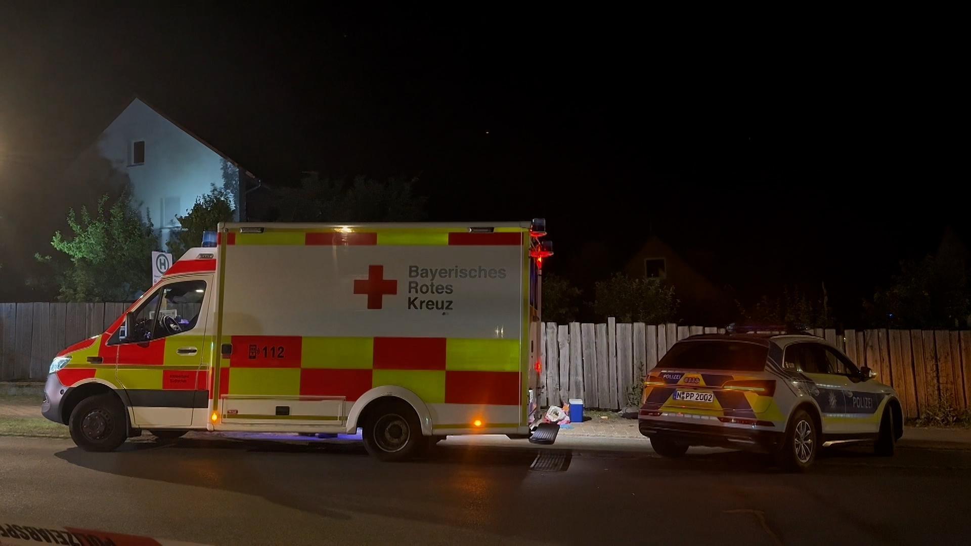 Am Tatort vor einem Holzbretterzaun stehen ein Polizeiauto und ein Rettungswagen. In der Nähe des Brombachsees ist ein 15-Jähriger mit einem Messer getötet worden. Tatverdächtig ist eine 19-Jährige.