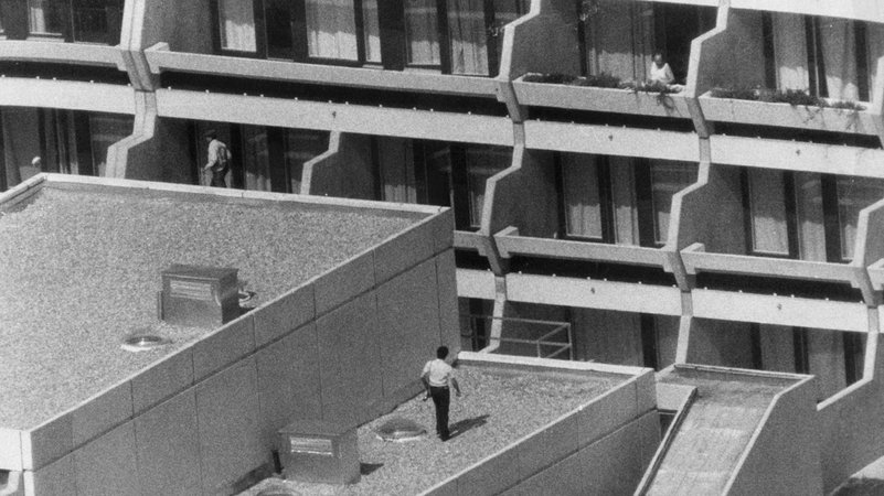 Bewaffnete Polizisten bewachen am 06.09.1972 auf einem Balkon und auf einem Dach des Münchner Olympischen Dorfes das Mannschaftsquartier des israelischen Teams. Arabische Terroristen der Untergrundorganisation "Schwarzer September" waren tags zuvor am frühen Morgen in das Dorf eingedrungen und hatten neun israelische Athleten in ihre Gewalt gebracht und zwei erschossen. Ihr Ultimatum: Freilassung von 200 gefangenen Palästinensern und freier Abzug mit den übrigen Geiseln. | Bild: dpa / picture-alliance Bewaffnete Polizisten bewachen am 06.09.1972 auf einem Balkon und auf einem Dach des Münchner Olympischen Dorfes das Mannschaftsquartier des israelischen Teams. Arabische Terroristen der Untergrundorganisation "Schwarzer September" waren tags zuvor am frühen Morgen in das Dorf eingedrungen und hatten neun israelische Athleten in ihre Gewalt gebracht und zwei erschossen. Ihr Ultimatum: Freilassung von 200 gefangenen Palästinensern und freier Abzug mit den übrigen Geiseln.
