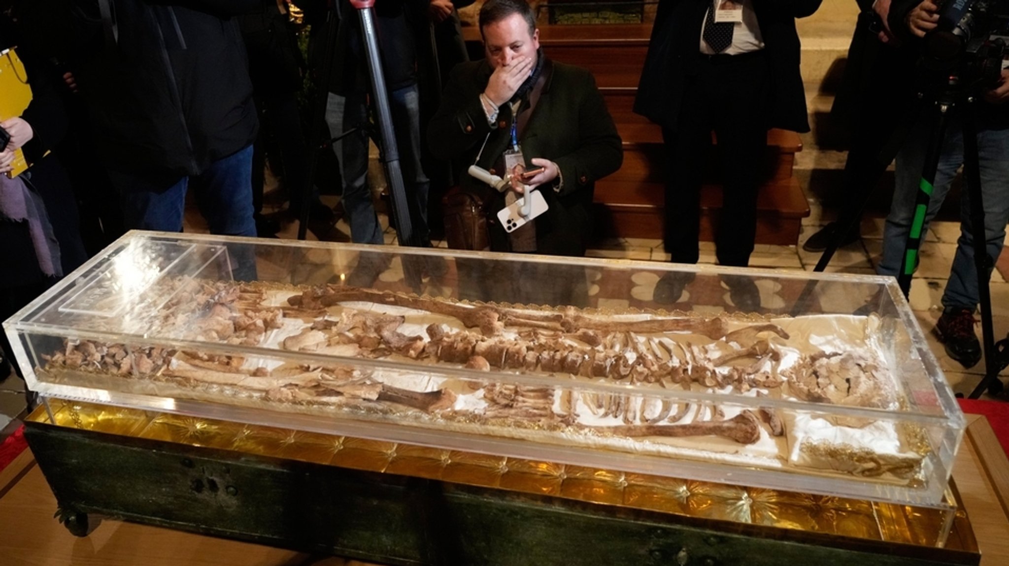 21.02.2026, Italien, Assisi: Journalisten fotografieren die sterblichen Überreste von Franz von Assisi in der päpstlichen Basilika San Francesco. 