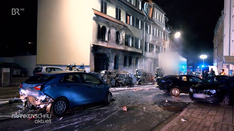 Zerstörte und qualmende Autos in der Fürther Hardstraße.