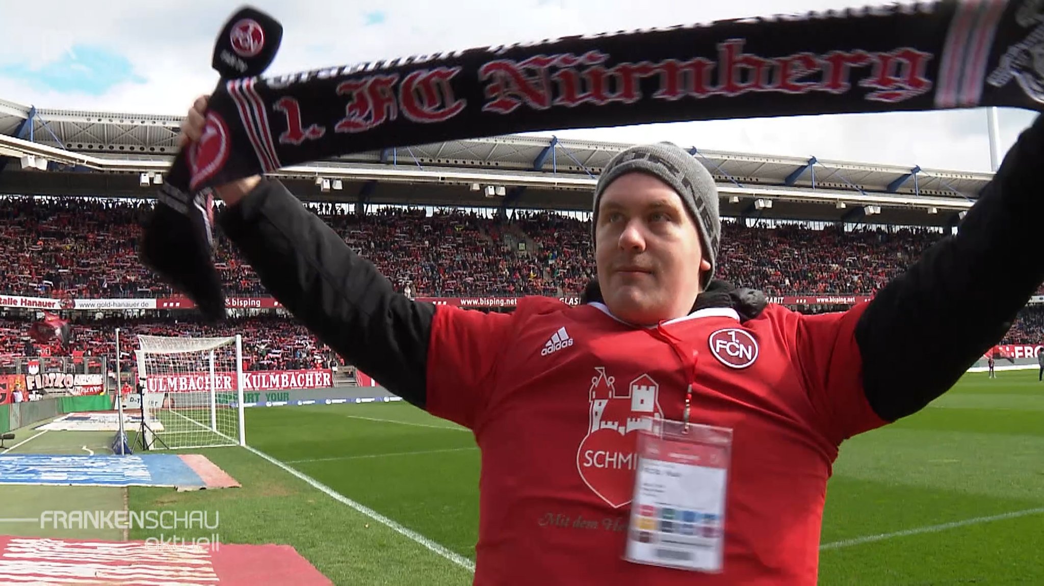 Ein Fußballfan steht mit seinem FCN-Schal auf dem Rasen im MAx-Morlock-Stadion.