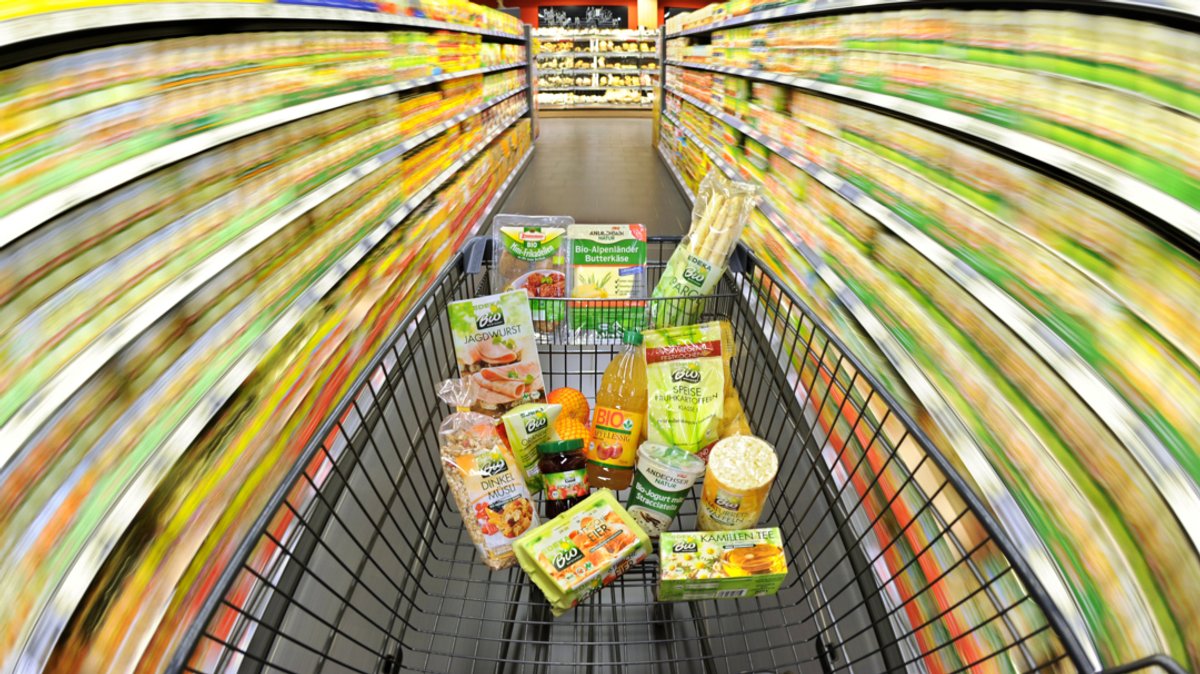 Ein Einkaufswagen mit Lebensmitteln wird durch einen Supermarkt in Hannover geschoben.