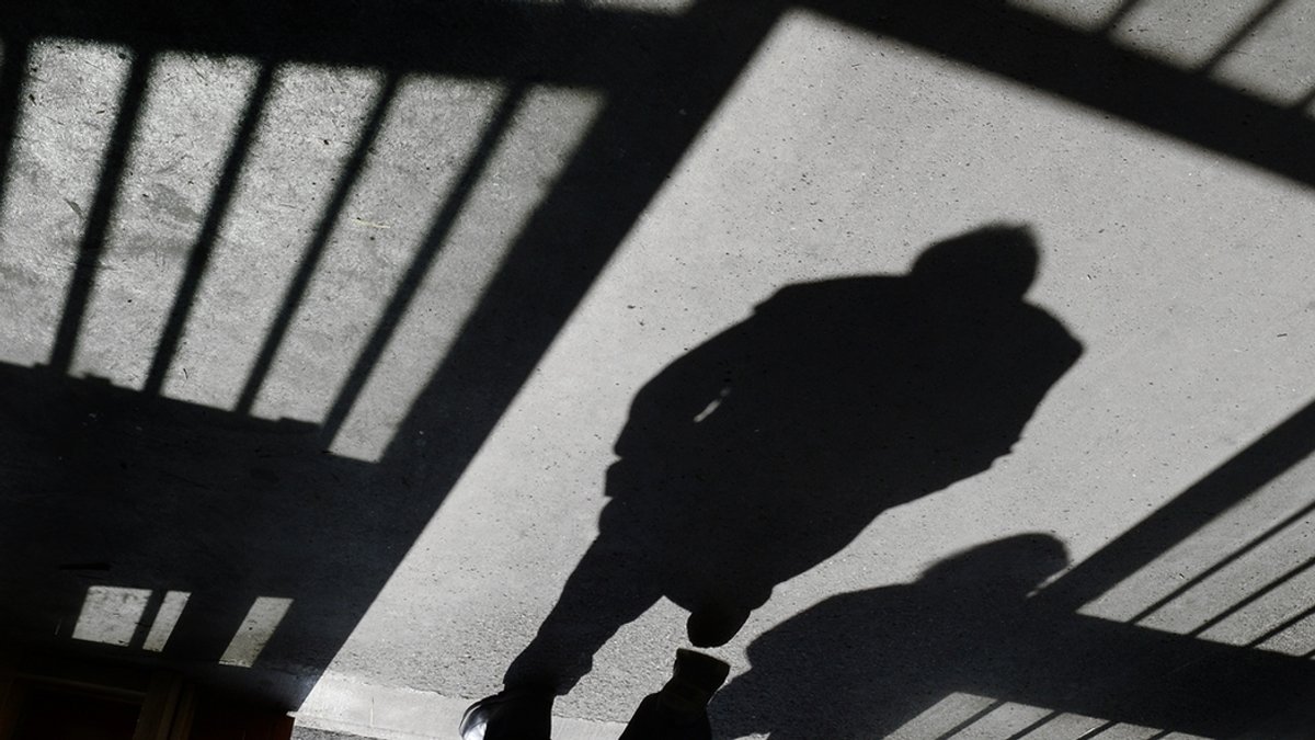 Symbolbild: Eine Schattenfigur geht durch ein offenes Gefängnistor