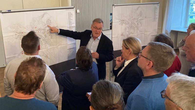 Oberbürgermeister zeigt auf einen Stadtplan, davor Bürger, die ihm zuschauen. | Bild: Stadt Bamberg, Michael Memmel Oberbürgermeister zeigt auf einen Stadtplan, davor Bürger, die ihm zuschauen.
