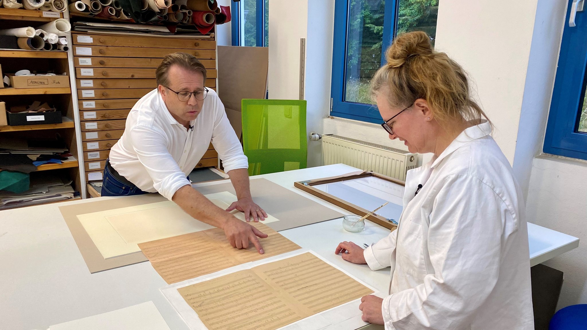 Buchrestauratorin Sonja Wallinger prüft zusammen mit Werner Obermeier die restaurierten Dokumente