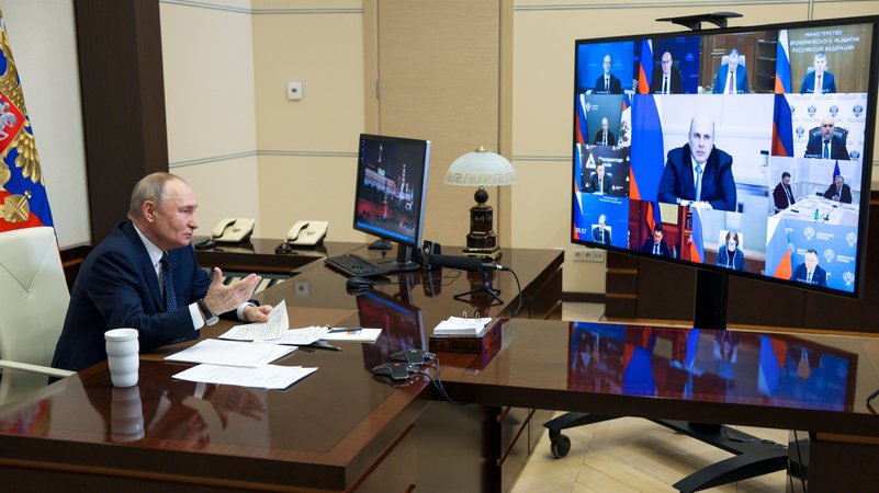 Der russische Präsident sitzt am Schreibtisch vor einem Videobildschirm | Bild: Gavriil Grigorov/Picture Alliance Der russische Präsident sitzt am Schreibtisch vor einem Videobildschirm