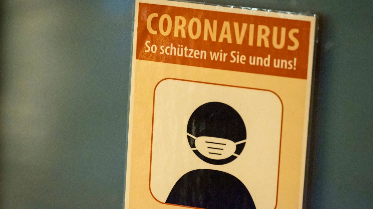 Ein Schild mit der Aufschrift ·Coronavirus - So schützen wir Sie und uns! - Bitte FFP2 Maske tragen· hängt an der Tür eines Geschäfts. 