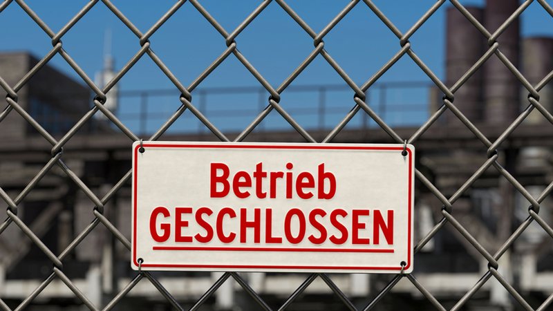 Schild: Betrieb geschlossen an einem Zaun vor einem Werksgelände. | Bild: stock.adobe.com/bluedesign Schild: Betrieb geschlossen an einem Zaun vor einem Werksgelände.