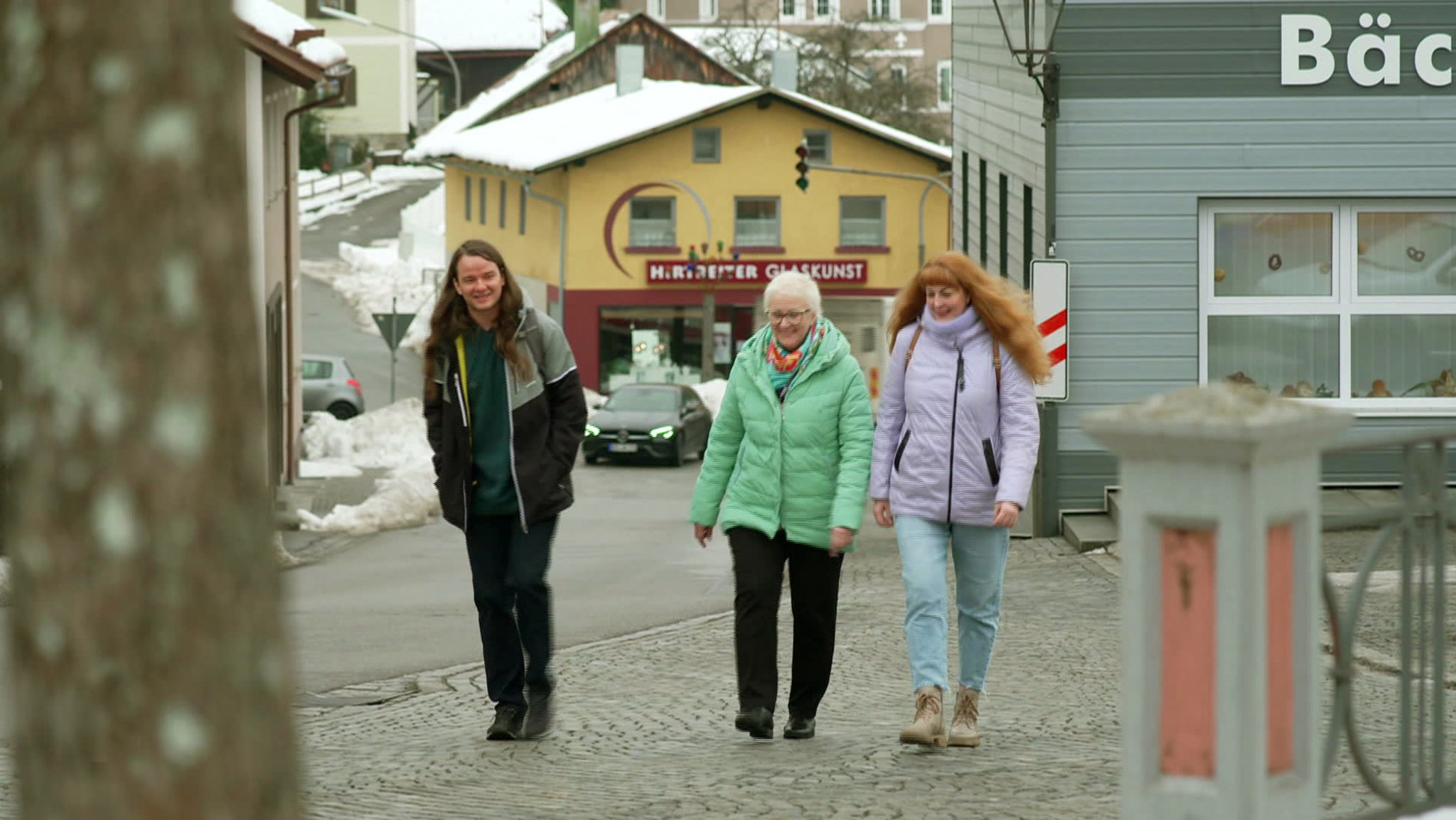 Drei Menschen in Frauenau auf dem Bürgersteig gehend