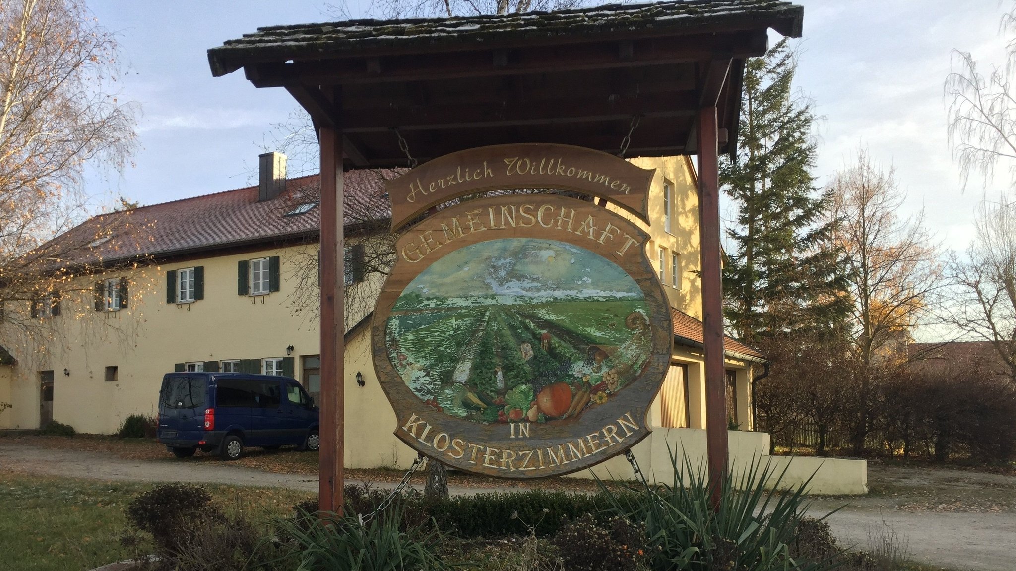 Ein Holzschild vor dem ehemaligen Anwesen der Zwölf Stämme in Klosterzimmern zeigt die Aufschrift: Herzlich Willkommen - Gemeinschaft in Klosterzimmern