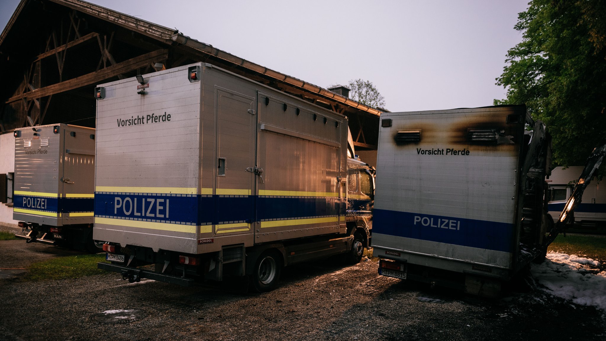 Zerstörte Polizeifahrzeuge neben den Stallungen