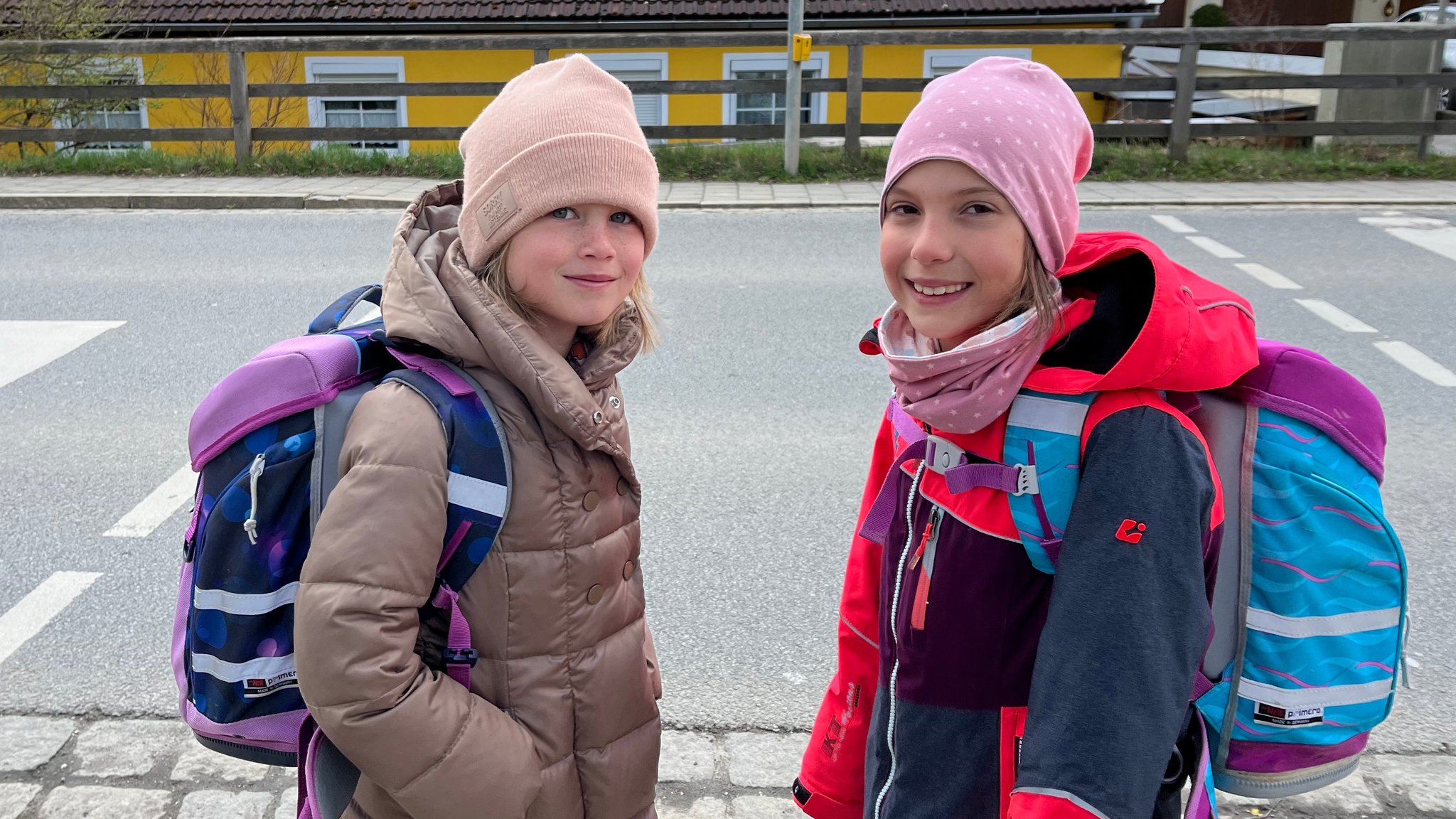 Emilia (l.) und Hannah stehen an einer Fußgängerampel.