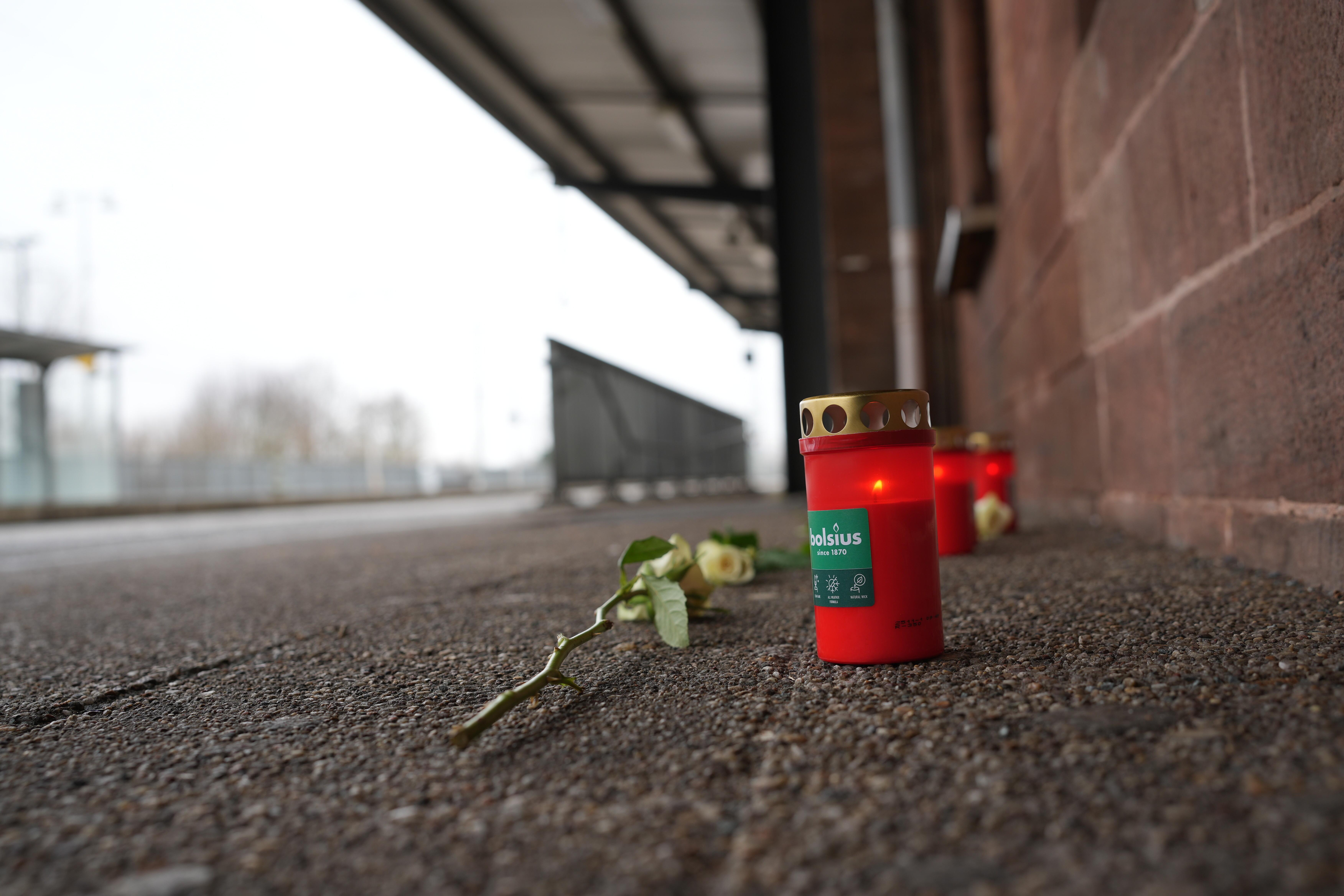Eine Blume und Kerzen liegen am Bahnsteig nach dem Tod eines Zugbegleiters