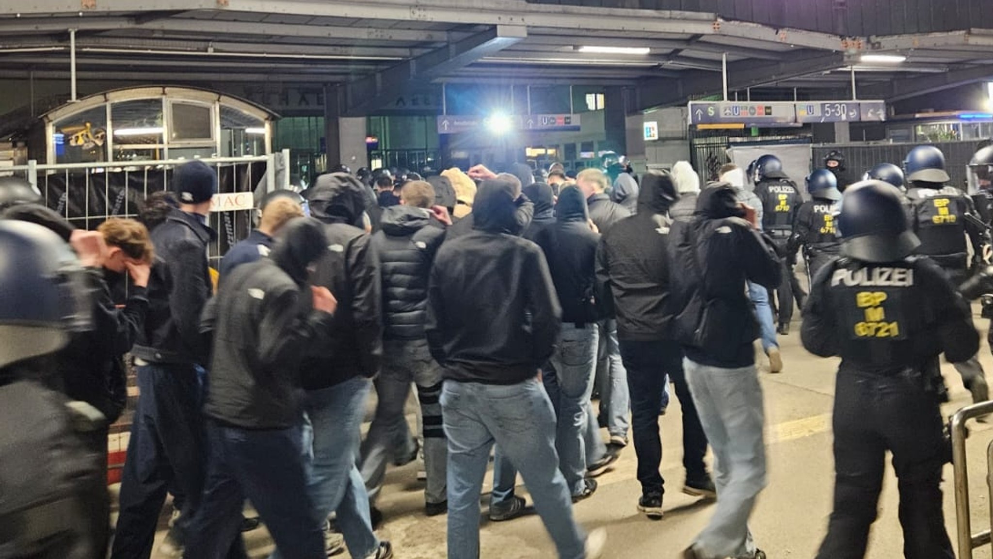 Bundespolizisten begleiten Fußballfans, die sich auf der Fahrt vorher aufgeführt haben und randaliert haben am Münchner Hauptbahnhof.