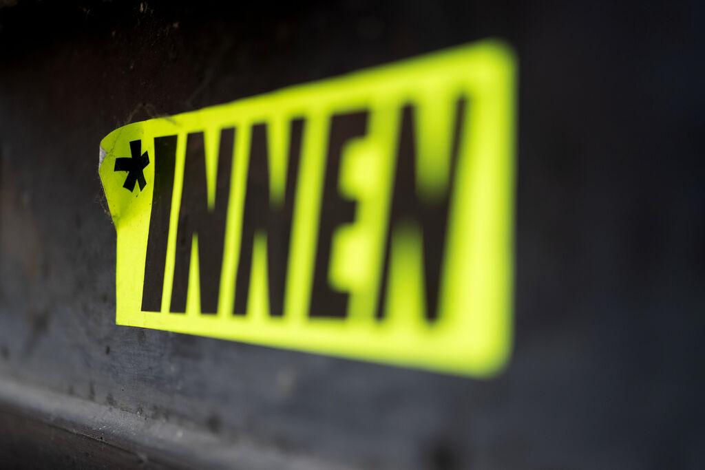 Ein Aufkleber mit der Aufschrift "*INNEN" ist in der Stuttgarter Innenstadt zu sehen.