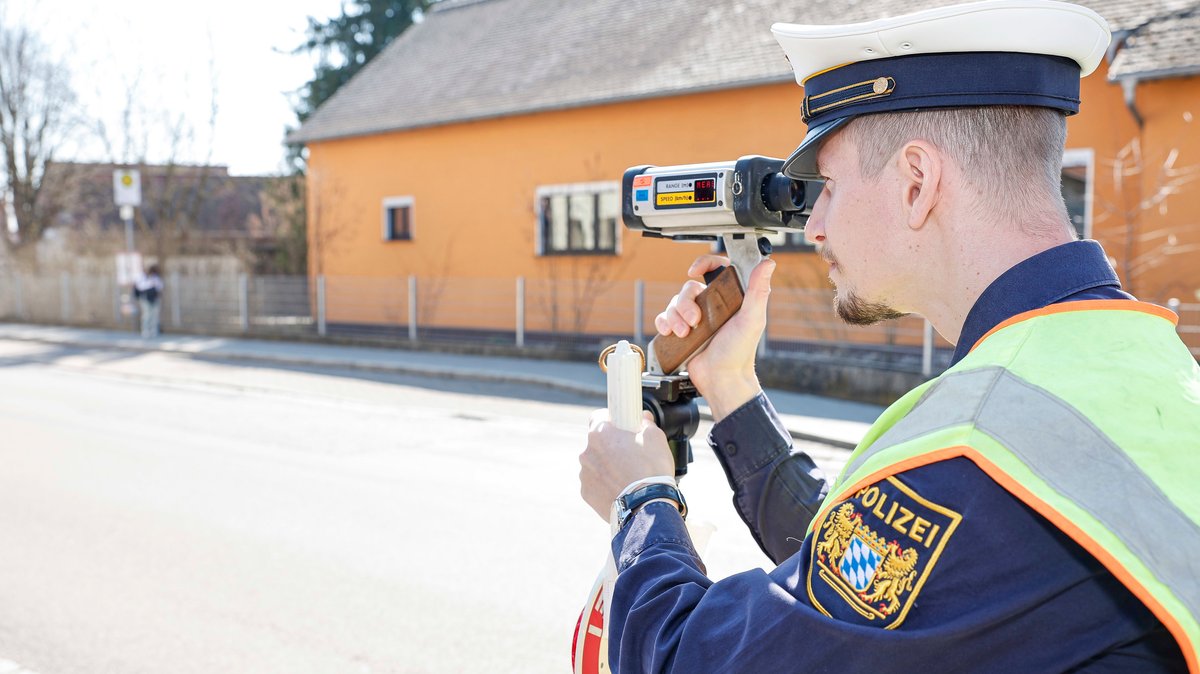 Ein Polizist mit einem Laser-Messgerät bei einer Geschwindigkeitskontrolle