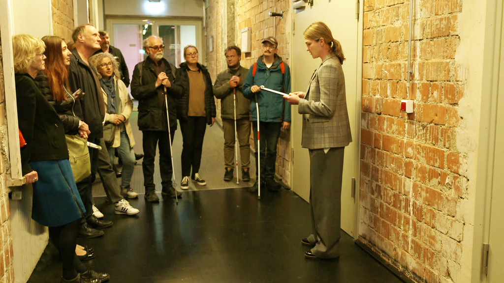 Audiodeskriptorin Anja Flessa (rechts) mit Theaterbesuchern mit Sehbehinderung in den Räumen der Münchner Kammerspiele