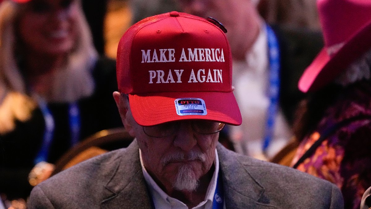 Mann mit einer roten Baseball-Kappe mit der Aufschrift "Make America Pray Again"