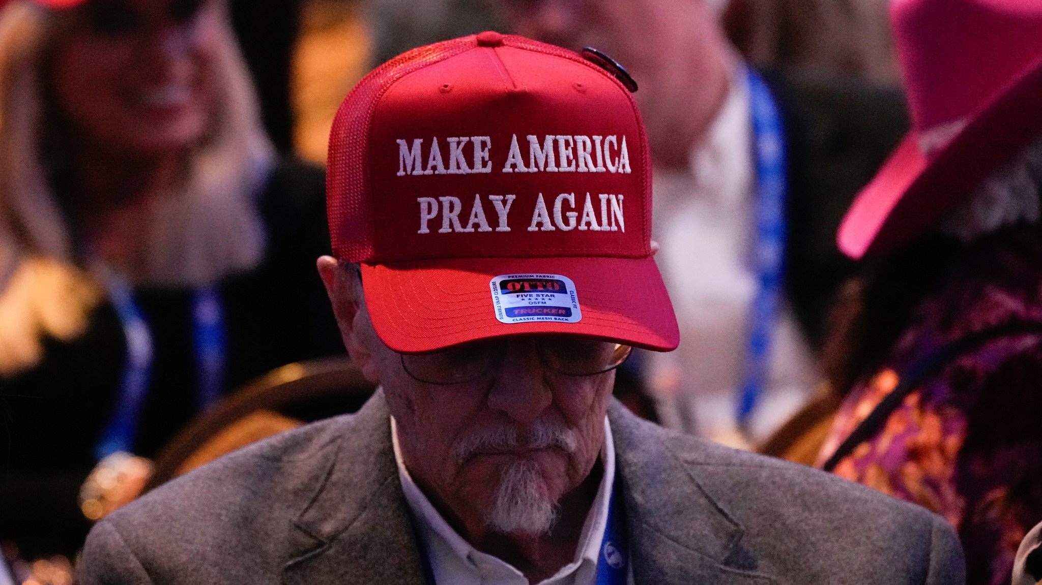 Mann mit einer roten Baseball-Kappe mit der Aufschrift "Make America Pray Again"