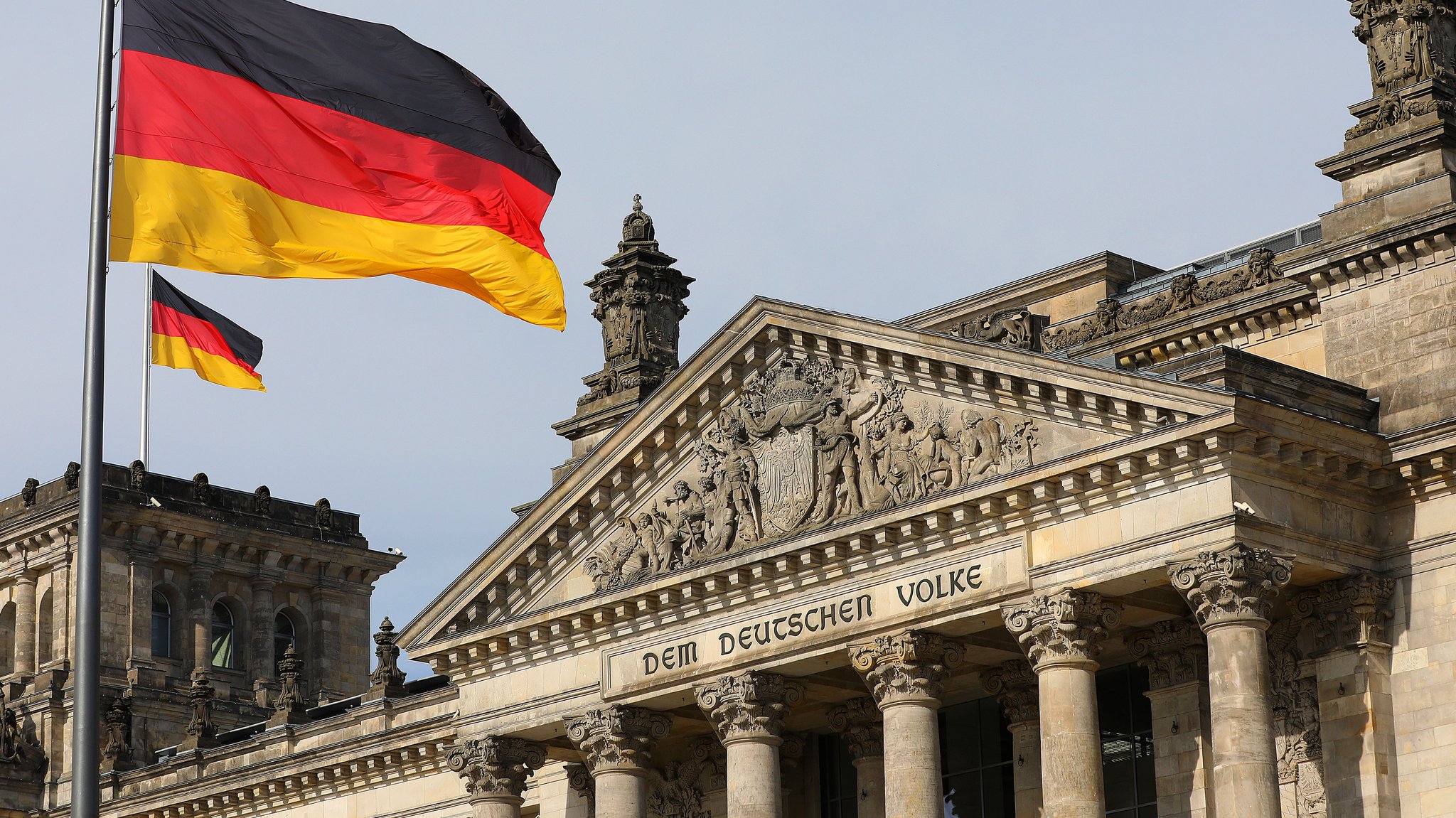 Das Reichstagsgebäude mit der Deutschland-Flagge am Platz der Republik in Berlin.
