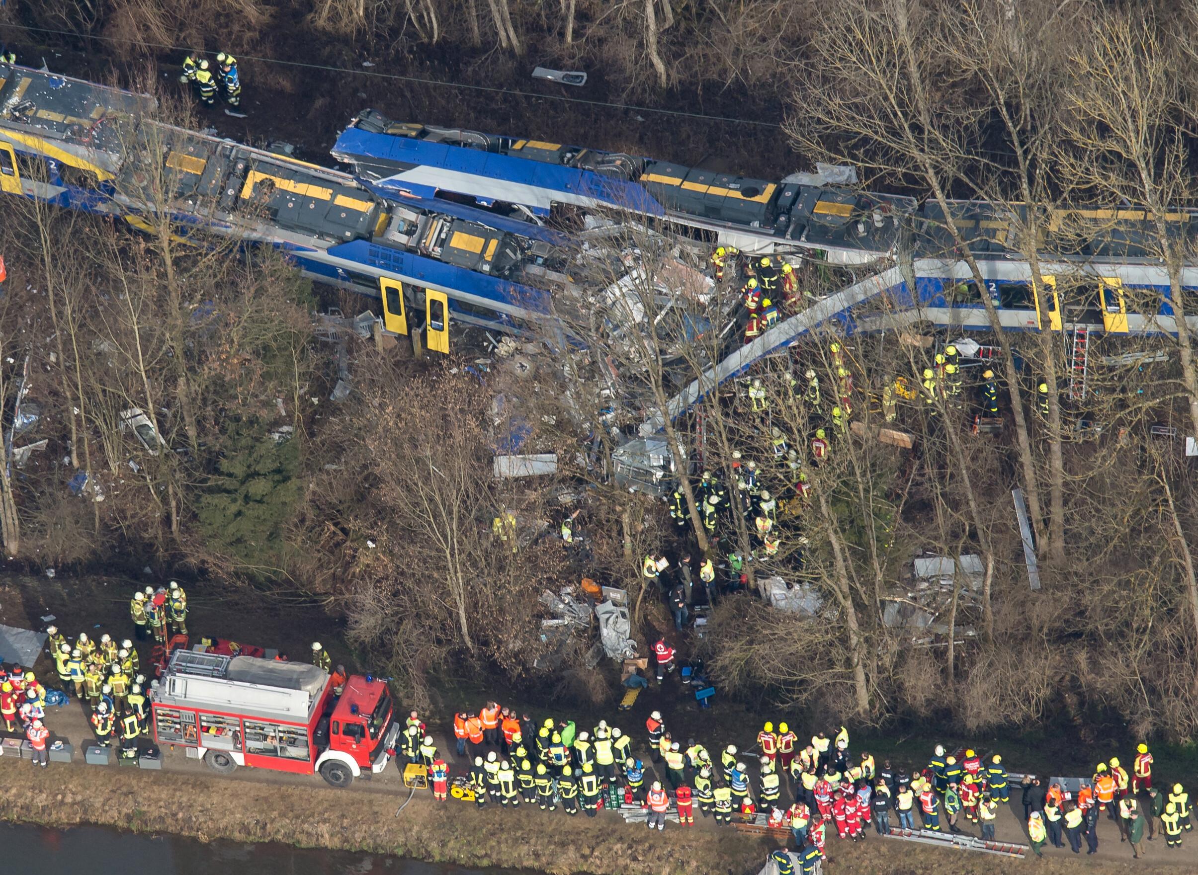 Rettungskräfte stehen am 09.02.2016 an der Unfallstelle eines Zugunglücks in der Nähe von Bad Aibling (Bayern). 