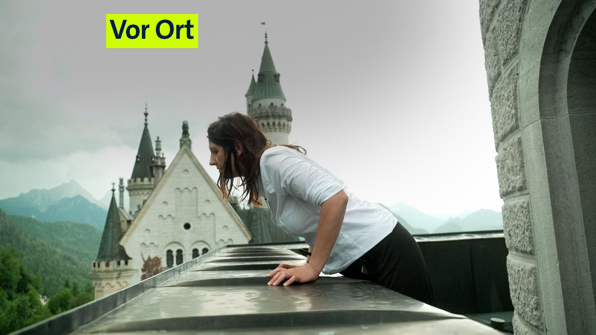 Kastellanin Martina Neuner blickt vom Balkon des Viereckturms in den Schlosshof. Im Hintergrund: der Hauptturm, der Palas des Schlosses und die Allgäuer Berge.