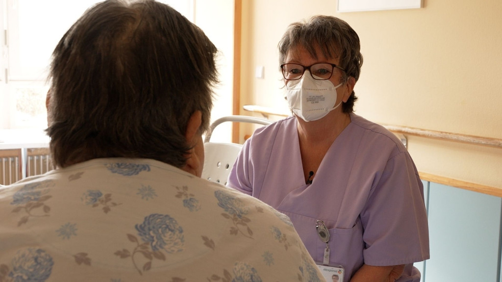 Eine ehrenamtliche Helferin spricht mit einer Patientin im Klinikum Rothenburg an der Tauber.