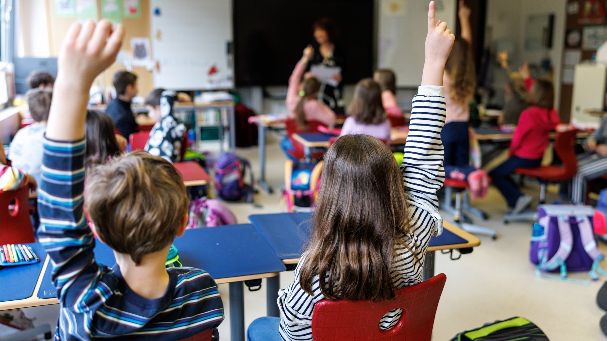 Schüler sitzen während einer Unterrichtsstunde auf ihren Plätzen im Klassenzimmer und melden sich. | Bild: picture alliance/dpa | Matthias Balk Schüler sitzen während einer Unterrichtsstunde auf ihren Plätzen im Klassenzimmer und melden sich.