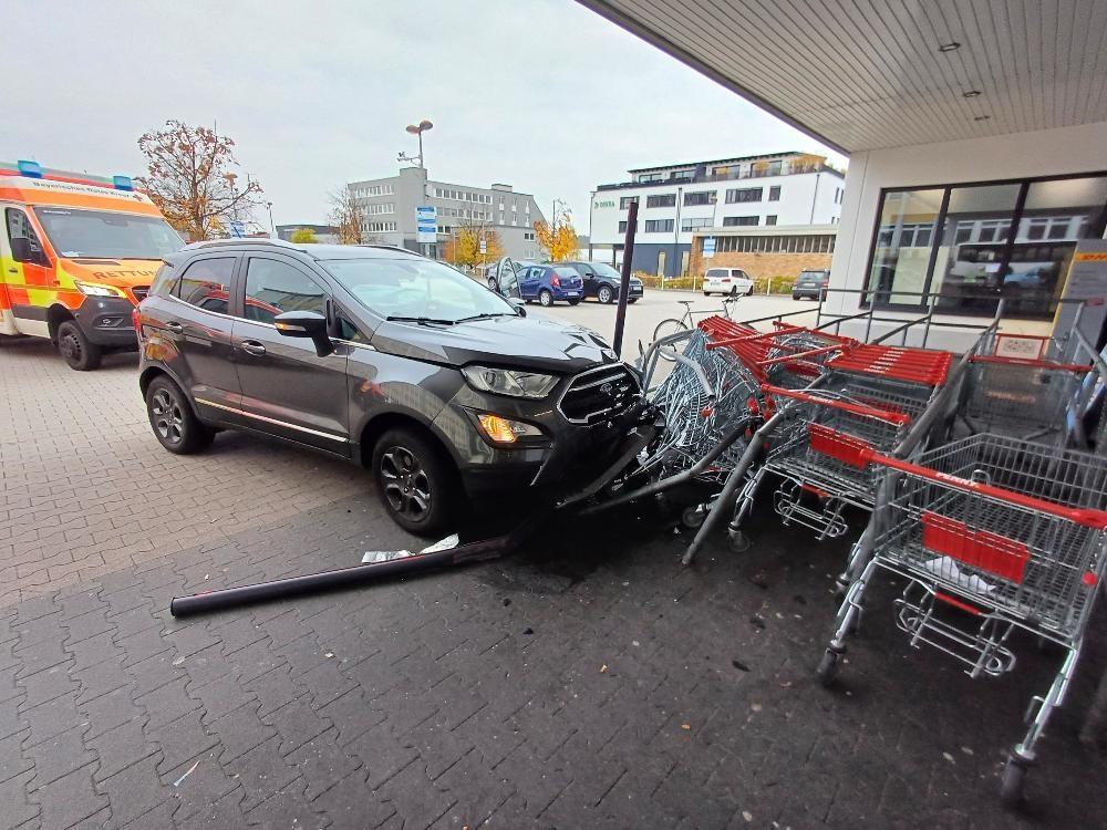 Ein Auto ist gegen die abgestellten Einkaufswagen vor einem Supermarkt geprallt