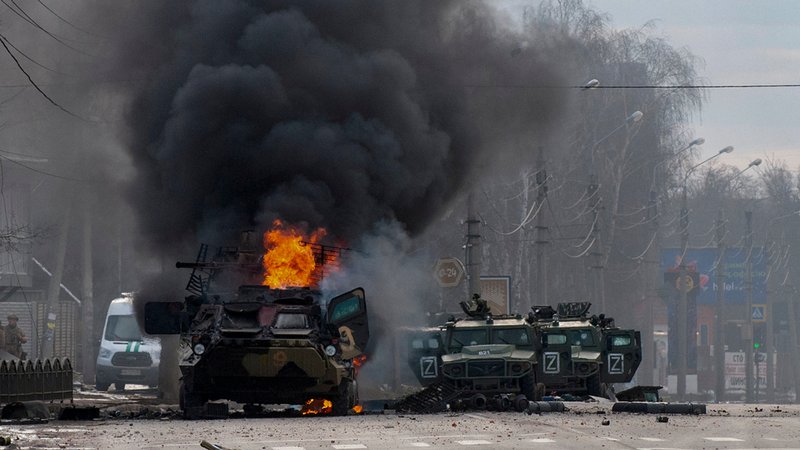 Ukraine: Ein gepanzerter Mannschaftswagen brennt und Nutzfahrzeuge sind nach Kämpfen in Charkiw beschädigt.